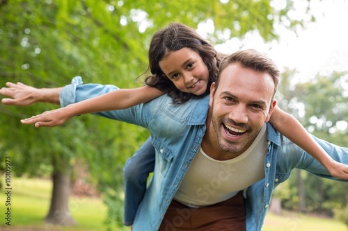 Father giving piggyback ride to daughter photo