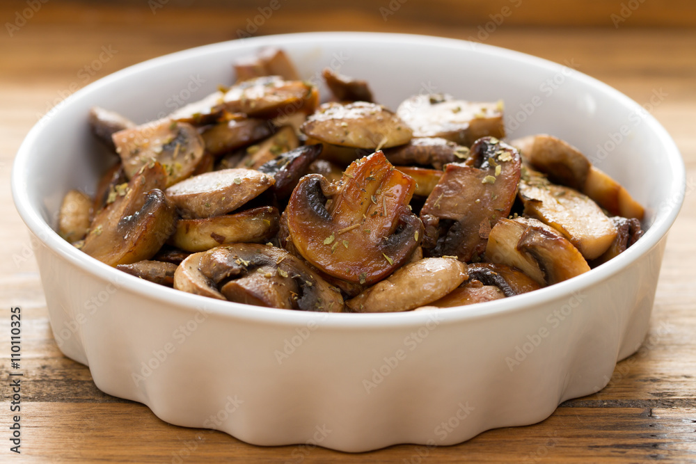 fried mushrooms on white dish on brown wooden background fried mushrooms on white dish on brown wooden background