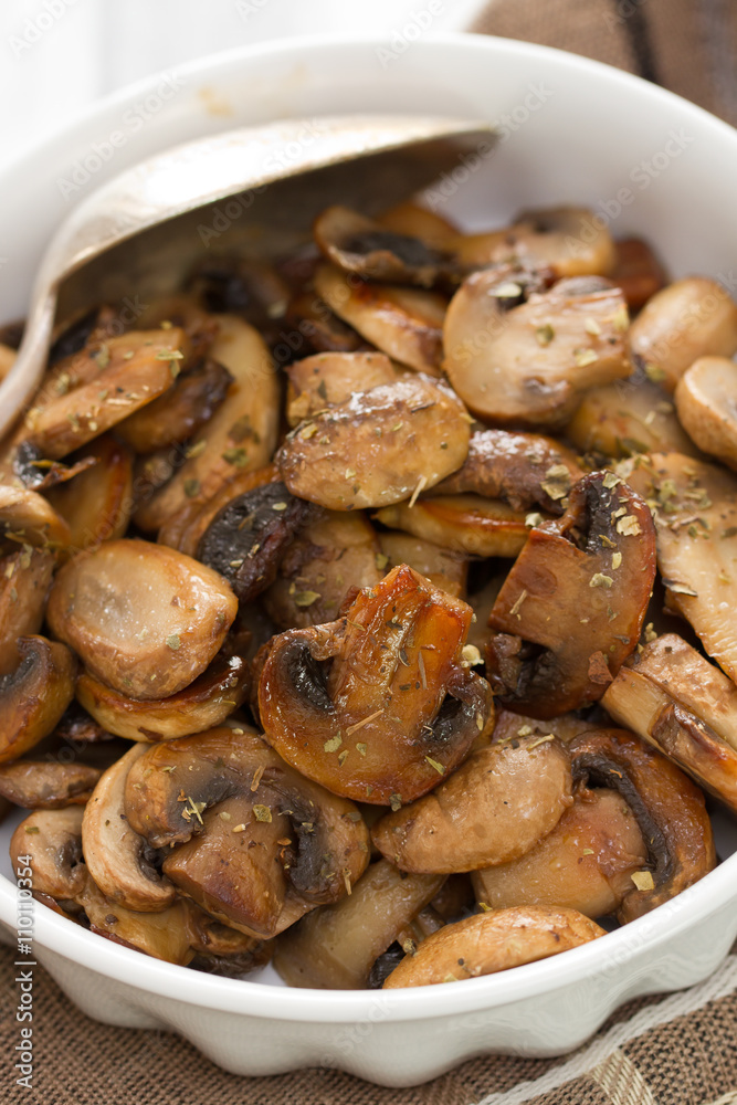 fried mushrooms on white dish on brown wooden background fried mushrooms on white dish on brown wooden background