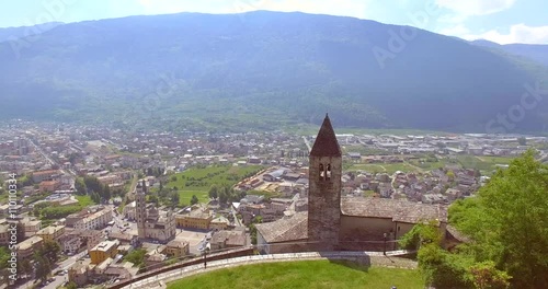 Aerial 4k - Tirano - Valtellina (IT) - Chiesetta di Santa Perpetua (Sec. VI) - Vista della Città e del Santuario della Beata Vergine  photo