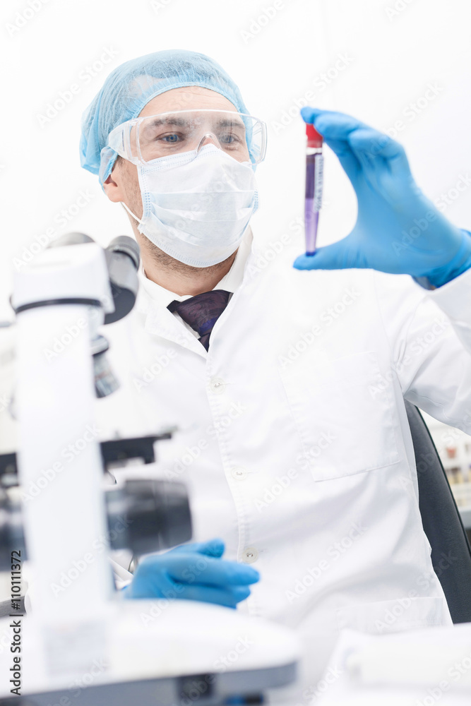Cheerful male researcher is working in laboratory Cheerful male researcher is working in laboratory