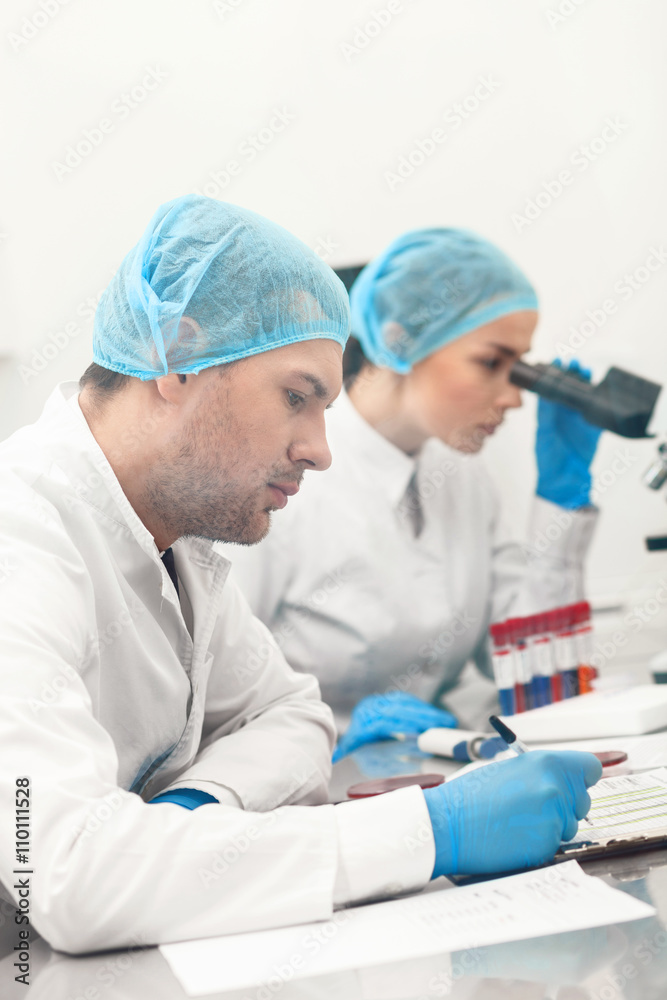 Cheerful young researchers are working in cooperation Cheerful young researchers are working in cooperation