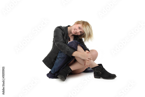 lächelnde junge Frau sitzt auf dem Boden