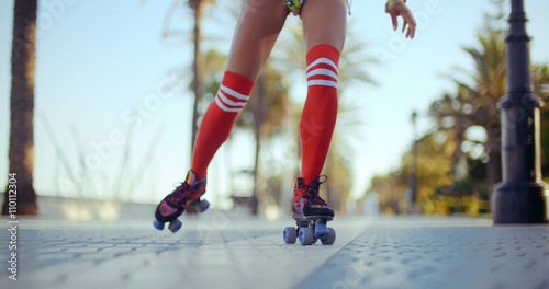 Low Angle Shot of Roller Skating Girl Riding on Tropical Beach Promenade at Sunset. Slow Motion Video Recorded at 120fps © Dash