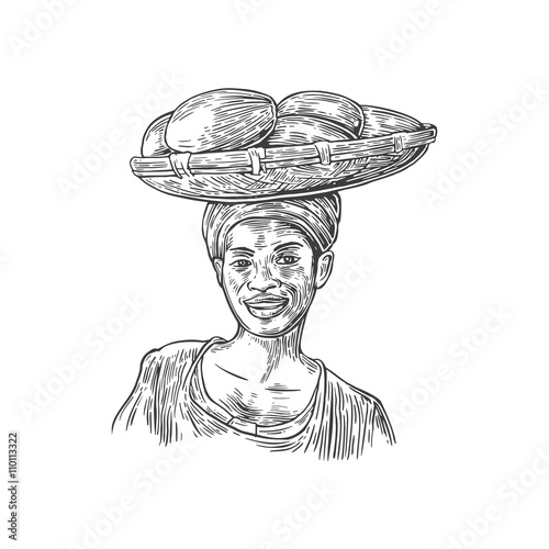 African woman carries a basket with baobab fruits on her head