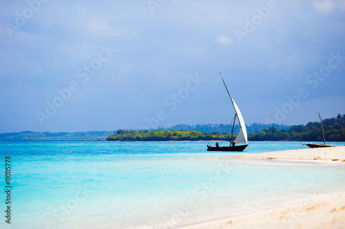 Old wooden dhow on white beach in the Indian Ocean 