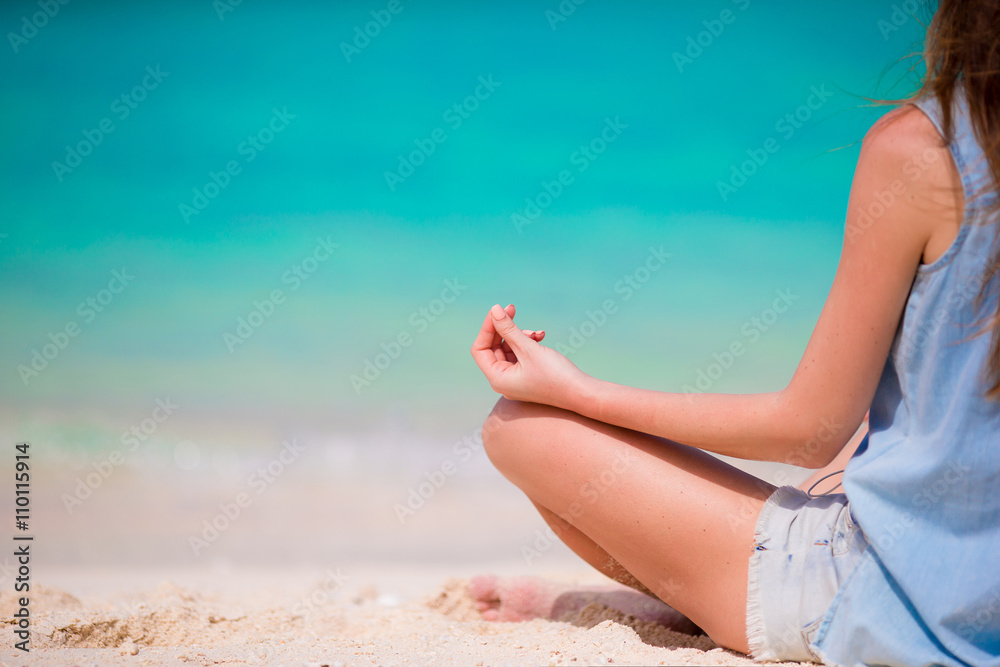 Body of beautiful woman in a meditation on the beach Body of beautiful woman in a meditation on the beach
