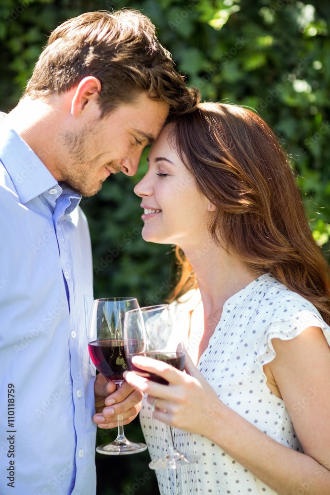 Romantic couple holding wineglasses at front yard Romantic couple holding wineglasses at front yard