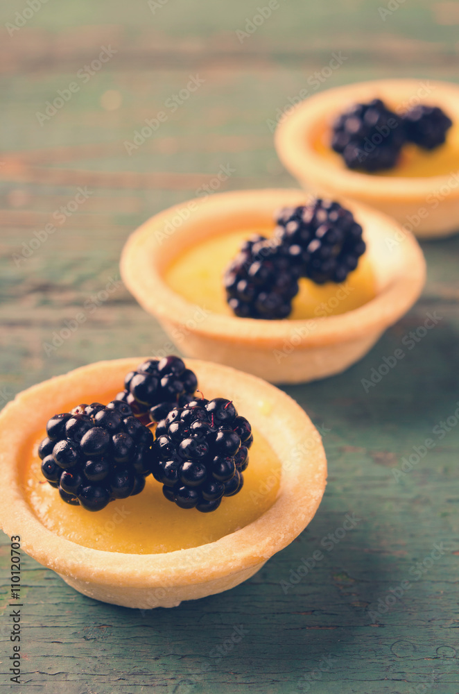 Homemade round tartlets with lemon curd and fresh blackberries Homemade round tartlets with lemon curd and fresh blackberries