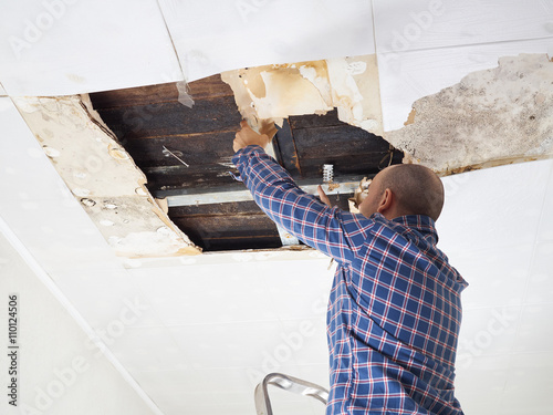 Man repairing collapsed ceiling.