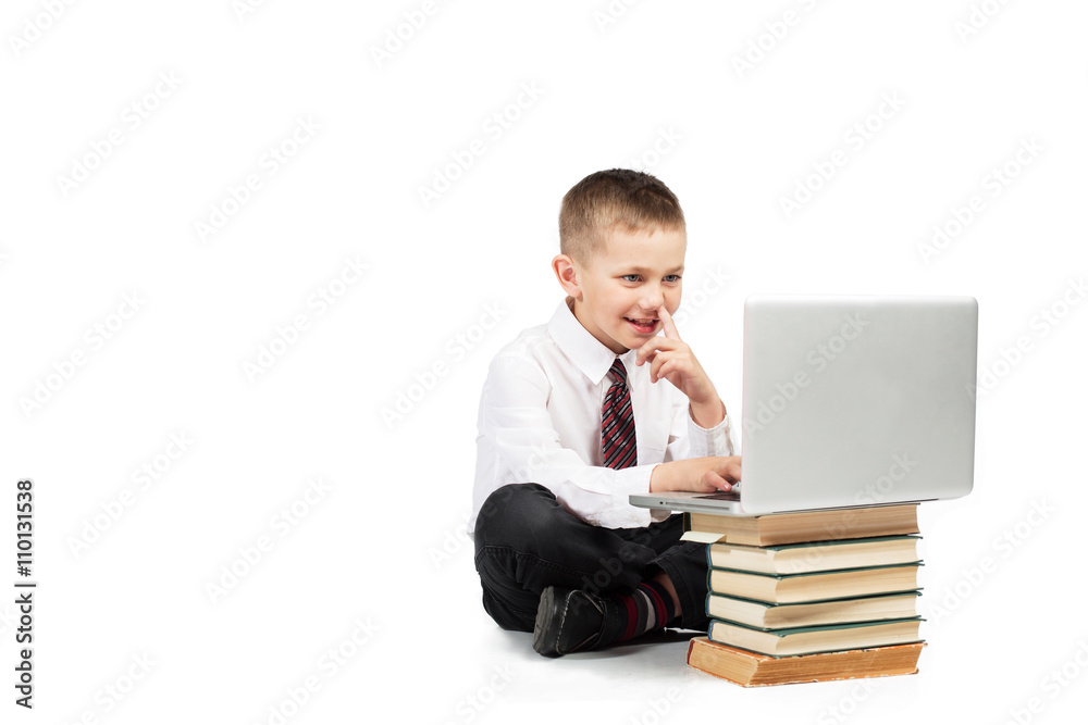 Little Happy Funny Boy sitting with laptop computer and school books. Technology education. White background isolated Little Happy Funny Boy sitting with laptop computer and school books. Technology education. White background isolated