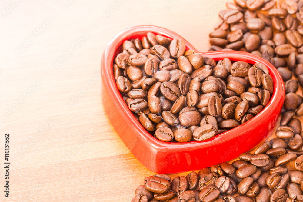 Coffee beans in red heart on wood background Coffee beans in red heart on wood background