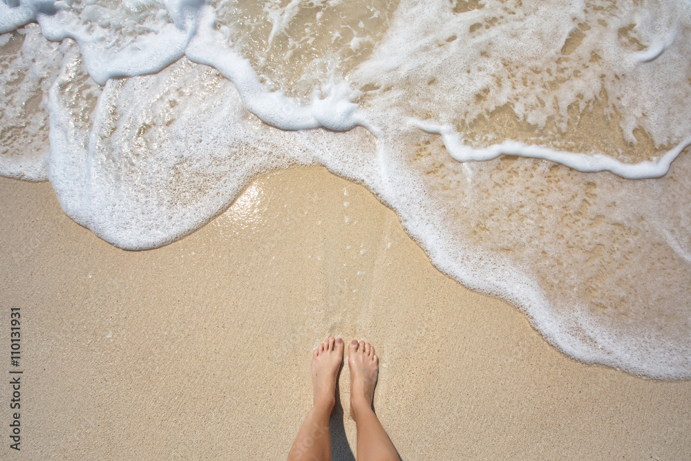 Vacation on ocean beach, feet on sea sand - obrazy, fototapety, plakaty 