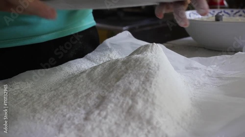 young woman in green shirts ifting flour in the kitchen photo