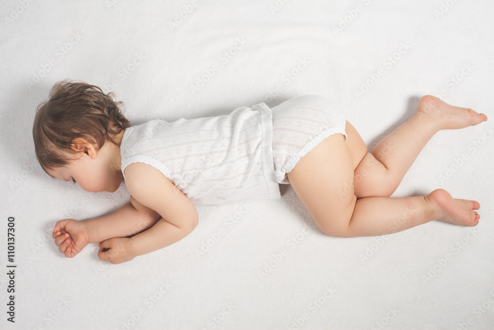 Naklejka premium Newborn baby sweet sleeping on a white bed