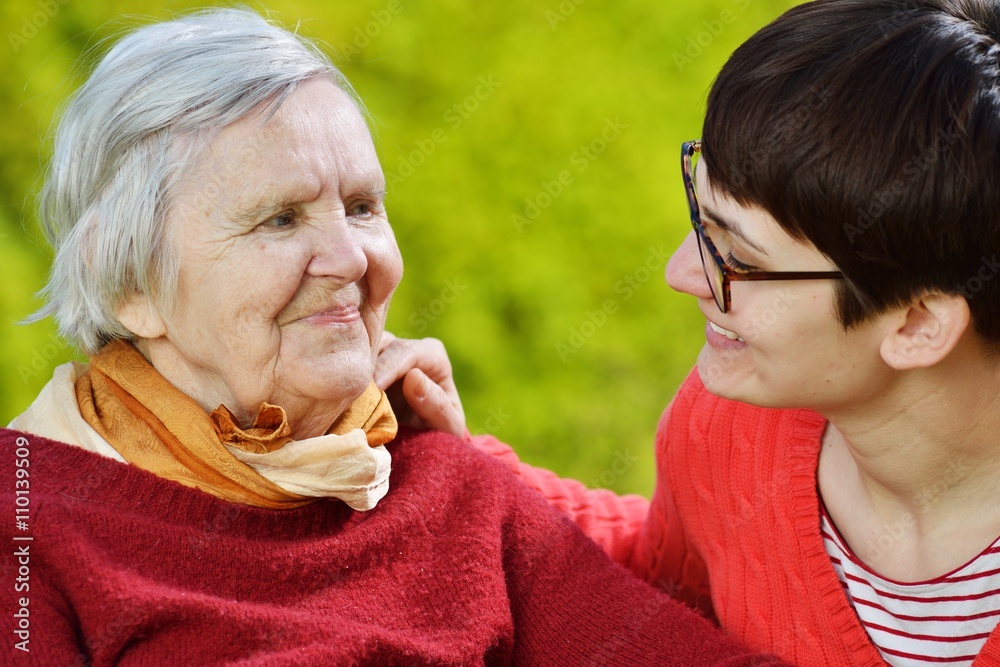 Grandmother and granddaughter. Young woman carefully takes care
