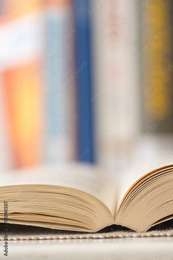 Obraz premium Detail view of open book in library. Shallow depth of field. Vertical shot.