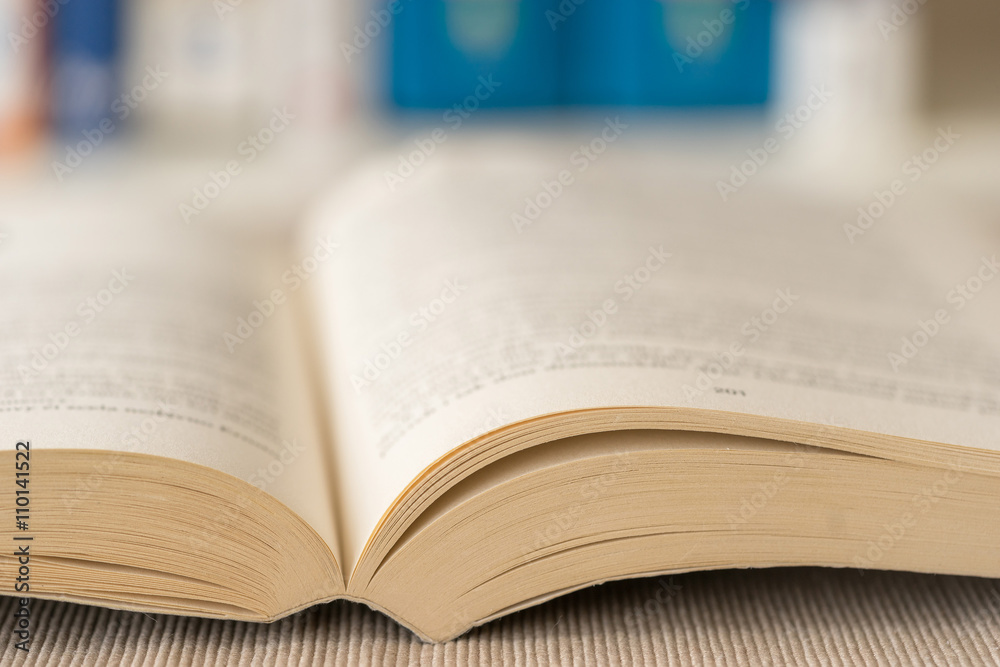 Obraz premium Detail view of open book in library. Selective focus. Horizontal shot.