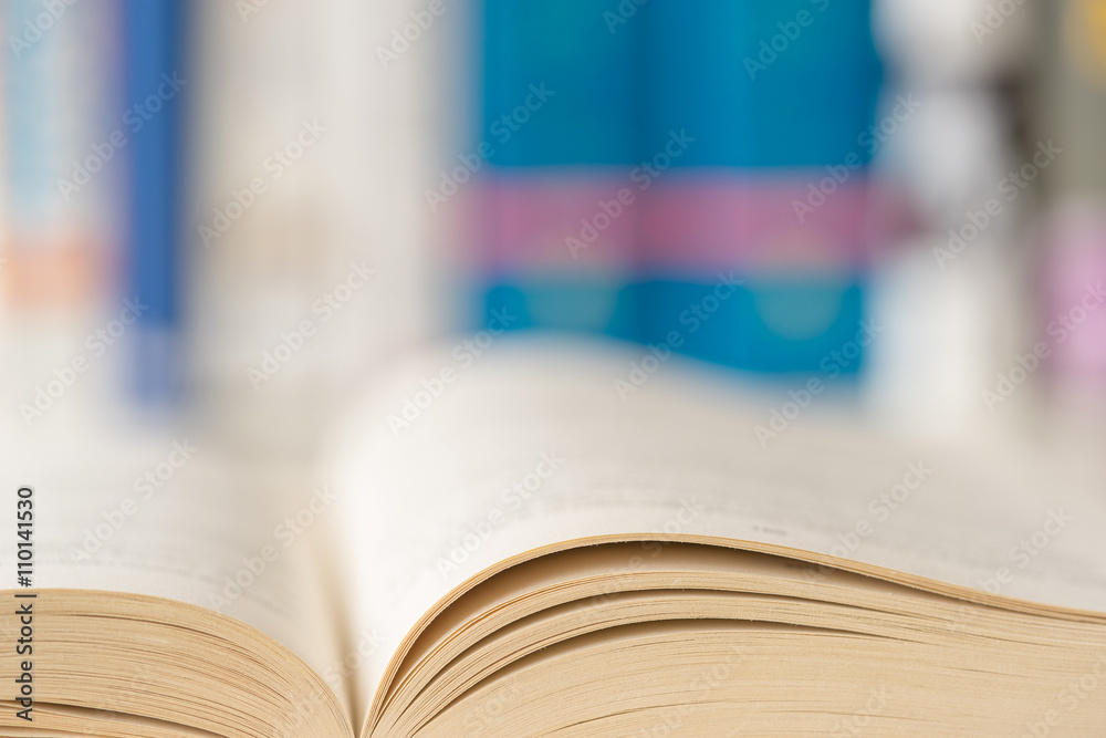 Obraz premium Detail view of open book in library. Shallow depth of field. Horizontal shot.