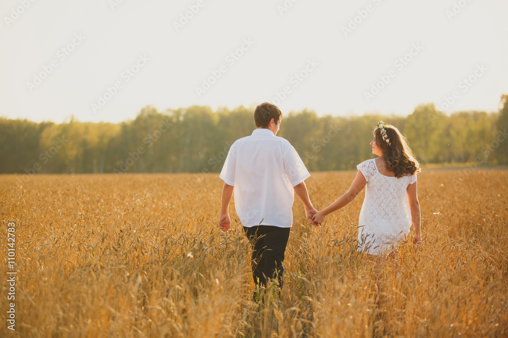romantic happy couple go on a wheat field.