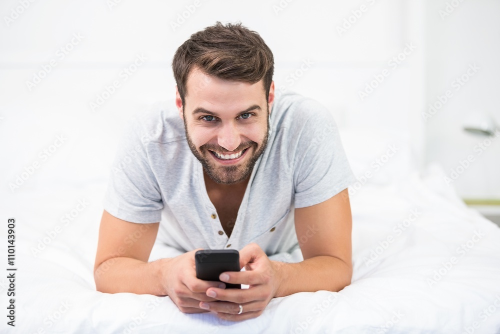 Portrait of happy man using mobile phone on bed Portrait of happy man using mobile phone on bed