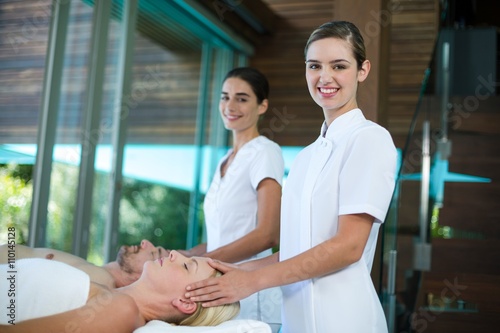 Woman receiving head massage from masseur photo
