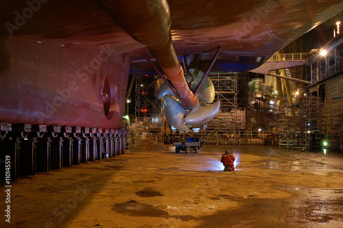 Welder welding on the hole in the hull during the renovation