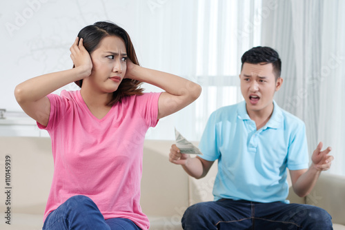 Young Vietnamese couple fighting about money at home