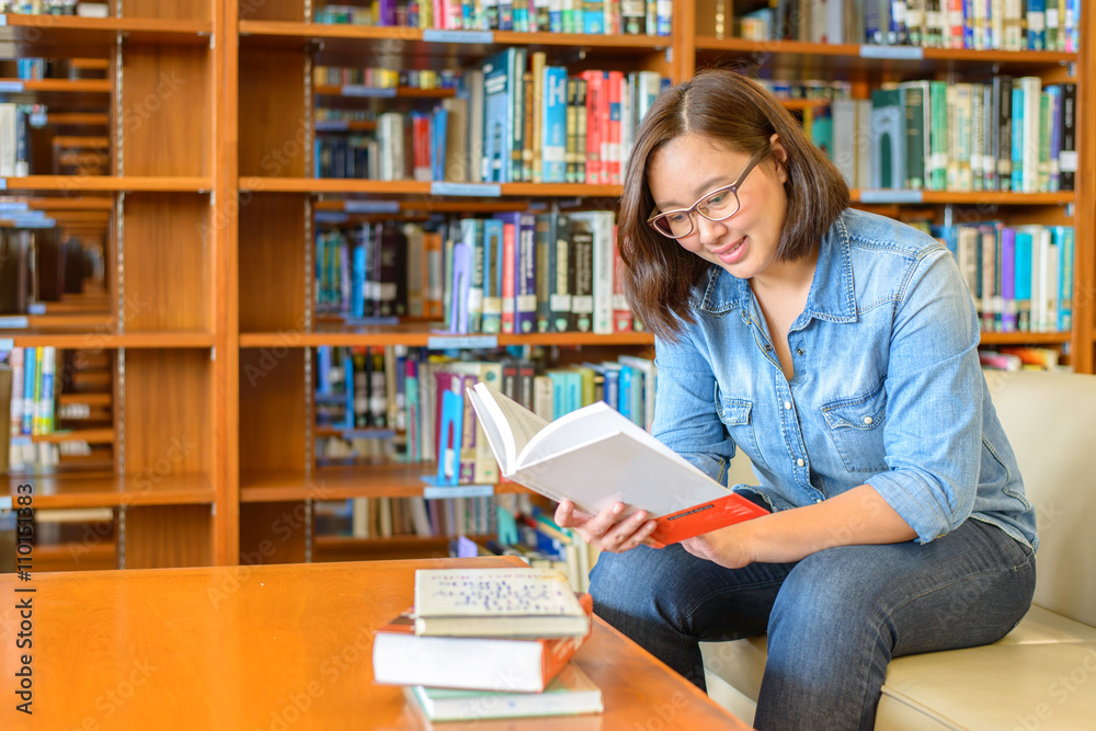 Portrait of a young student reading a book in a library Portrait of a young student reading a book in a library