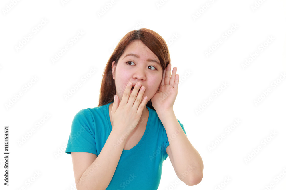耳に手を当てる女性