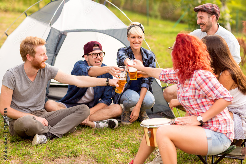 Male and female tapping with beer in front of tent