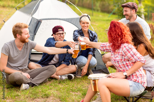 Male and female tapping with beer in front of tent