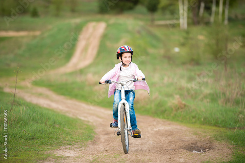 Fototapeta Naklejka Na Ścianę i Meble -  smiling little girl riding a bike 