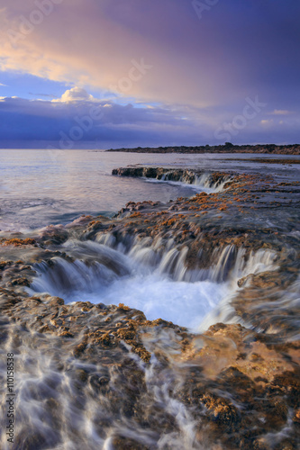 Sunset over the volcanic shore of Oahu island, Hawaii. Low tide long exposure landscape. Lava tunnels.