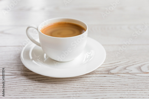 hot coffee in white cup on vintage wooden table