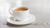 hot coffee in white cup on vintage wooden table