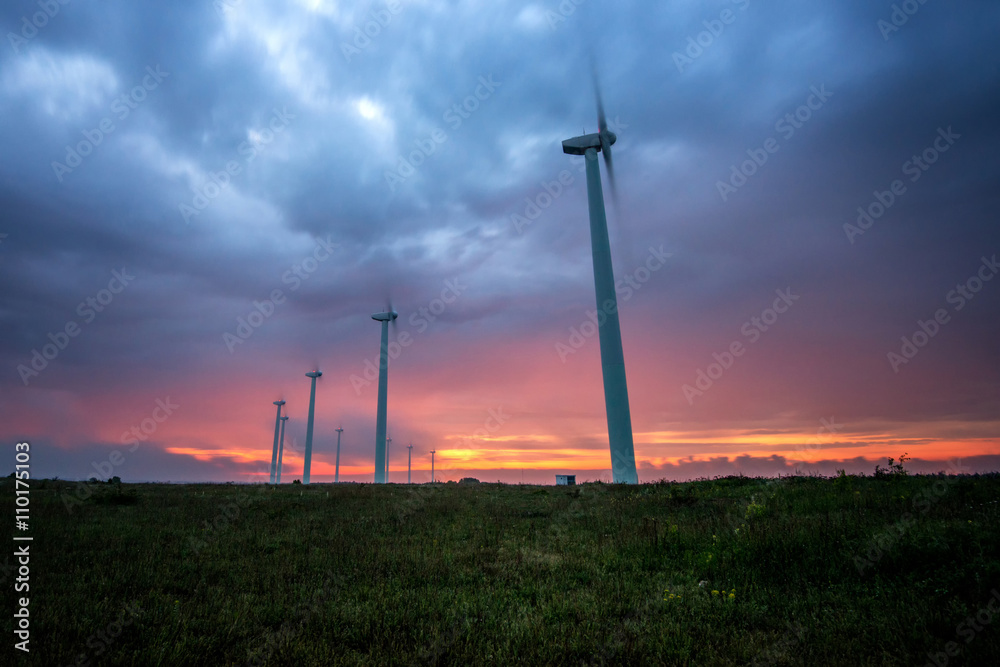 Obraz premium Wind turbines generating electricity against sunrise