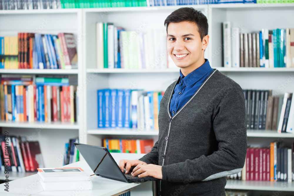 Happy student is learning in library.