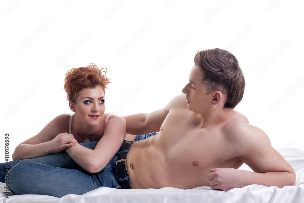 Red-haired girl and her boyfriend posing in bed Red-haired girl and her boyfriend posing in bed