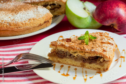 Apple pie with nuts and raisins drizzled with caramel syrup.