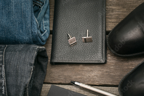 Male set for day from wallet, jeans and cufflinks on wooden board.