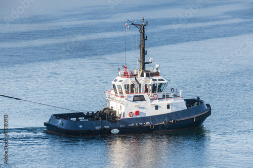 Tug boat with white superstructure underway