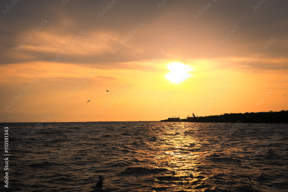Sunset at sea, with oil industry in the background. Sunset at sea, with oil industry in the background.