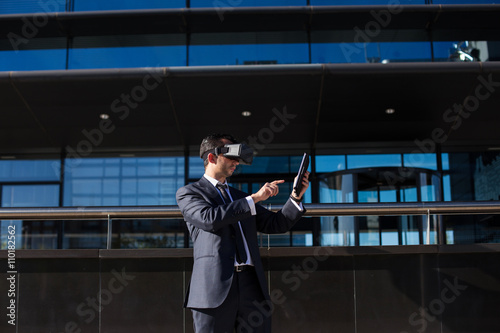 Businessman using tablet computer and virtual reality glasses