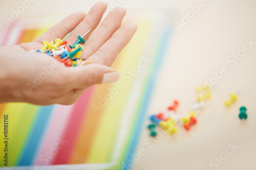Hand with colorful pushpins