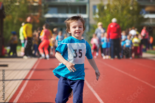 Young preschool children, running on track in a marathon competi photo