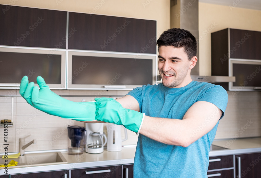 Man putting on rubber gloves Man putting on rubber gloves