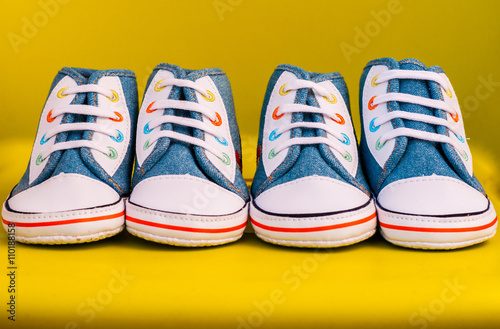 Baby sneakers on yellow background