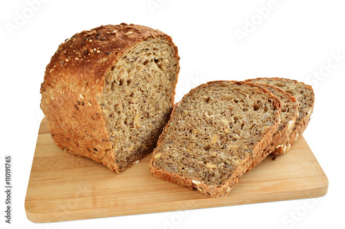 Loaf of brown whole grain bread with sunflower and sesame seeds sliced isolated on white background