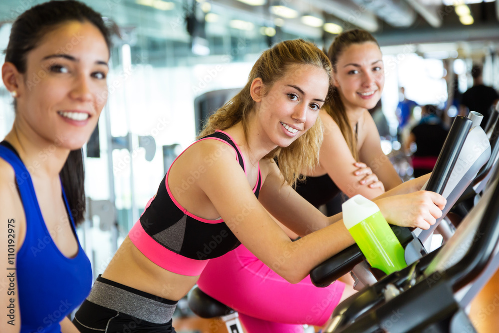 Group of people exercising their legs doing cardio training in g Group of people exercising their legs doing cardio training in g